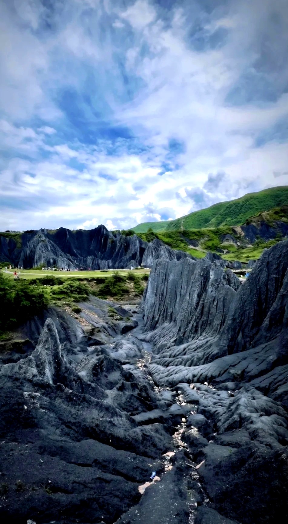 墨石公园新都桥,大面积黑色岩石地貌在草甸间延伸如外星地表,四川甘孜川西高原摄影景点