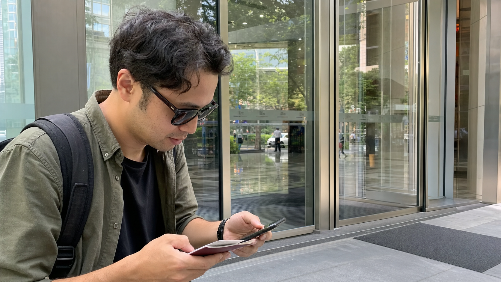 中国大陆银行门口前,旅人拿著证件与手机准备确认开户资料